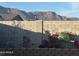 View of the block wall with a beautiful landscape of the mountain range, red flowers, and greenery at 12176 E Chevelon Trl, Gold Canyon, AZ 85118