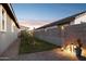 Side yard featuring desert landscaping, a block fence for privacy, and charming lantern lighting at 12176 E Chevelon Trl, Gold Canyon, AZ 85118