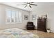 Bedroom featuring a ceiling fan, plantation shutters, a comfortable chair, and dresser at 12176 E Chevelon Trl, Gold Canyon, AZ 85118