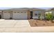 Charming home exterior with a three-car garage, desert landscaping, and a welcoming entrance at 12176 E Chevelon Trl, Gold Canyon, AZ 85118