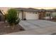 A well-maintained home with a two-car garage, desert landscaping, and a wide concrete driveway at 12176 E Chevelon Trl, Gold Canyon, AZ 85118