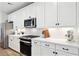 Modern kitchen featuring white cabinets, quartz countertops, stainless steel appliances and herringbone backsplash at 12176 E Chevelon Trl, Gold Canyon, AZ 85118