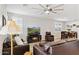 Spacious living room featuring dark leather furniture, ceiling fan, plantation shutters and tile floors at 12176 E Chevelon Trl, Gold Canyon, AZ 85118