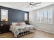 Inviting bedroom with a ceiling fan, plantation shutters, and dark blue accent wall at 12176 E Chevelon Trl, Gold Canyon, AZ 85118