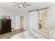 Bedroom featuring a ceiling fan, a barn door to the bathroom, and neutral color scheme at 12176 E Chevelon Trl, Gold Canyon, AZ 85118