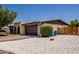 Exterior view of the house featuring a two-car garage and low-maintenance desert landscaping at 12811 N 44Th Dr, Glendale, AZ 85304
