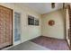 Cozy front porch featuring a wooden door with a brick-paved floor and wall decor at 12811 N 44Th Dr, Glendale, AZ 85304