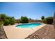 Backyard pool with stone landscaping, concrete patio, block wall, and lush trees offers an outdoor oasis at 12811 N 44Th Dr, Glendale, AZ 85304