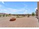 Backyard featuring a fire pit and desert landscaping with natural rocks and cactus at 17179 S 174Th S Dr, Goodyear, AZ 85338
