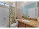 Bathroom featuring a granite vanity, framed mirror, and a shower-tub combo with curtain at 17179 S 174Th S Dr, Goodyear, AZ 85338