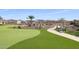 Artificial turf greens and walkway, with a seating bench, landscaped surroundings, and various neighborhood homes at 17179 S 174Th S Dr, Goodyear, AZ 85338