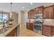 Kitchen featuring dark cabinetry, granite countertops, and stainless steel appliances with pendant lights at 17179 S 174Th S Dr, Goodyear, AZ 85338