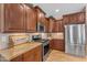 Well-equipped kitchen showcasing stainless steel appliances, custom wood cabinetry, and granite counters at 17179 S 174Th S Dr, Goodyear, AZ 85338