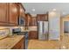 Modern kitchen featuring stainless steel appliances, dark wood cabinets, and granite countertops at 17179 S 174Th S Dr, Goodyear, AZ 85338