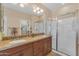 Main bathroom with double sinks, granite counters, a walk-in shower, and ample storage space at 17179 S 174Th S Dr, Goodyear, AZ 85338