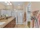 Main bathroom showcasing double sinks, a granite countertop, a walk-in shower, and a large walk-in closet at 17179 S 174Th S Dr, Goodyear, AZ 85338