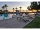 Community swimming pool with palm trees and lounge chairs, perfect for relaxation and recreation at 17179 S 174Th S Dr, Goodyear, AZ 85338