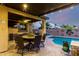 Outdoor dining area next to a sparkling pool in a well-landscaped backyard at 17363 W Lisbon Ln, Surprise, AZ 85388