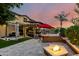 Outdoor entertainment area features a built-in grill, bar, fire pit, and lush landscaping at 17363 W Lisbon Ln, Surprise, AZ 85388