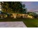 Lush backyard with manicured lawn, mature trees, and privacy landscaping offers a serene outdoor space at 17363 W Lisbon Ln, Surprise, AZ 85388