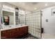 Elegant bathroom with double vanity, glass shower and ample lighting at 17363 W Lisbon Ln, Surprise, AZ 85388