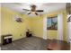 Bedroom with yellow walls, carpet flooring, ceiling fan and wood furniture at 17363 W Lisbon Ln, Surprise, AZ 85388