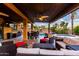 Relaxing covered patio with ceiling fan and multiple seating arrangements, overlooking a spa and outdoor dining area at 17363 W Lisbon Ln, Surprise, AZ 85388