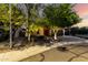 Beautiful single-story home with mature trees, desert landscaping, and warm lighting, creating an inviting ambiance at 17363 W Lisbon Ln, Surprise, AZ 85388