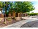 Beautiful single-story home with mature trees, desert landscaping, and warm lighting, creating an inviting ambiance at 17363 W Lisbon Ln, Surprise, AZ 85388