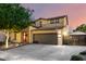 Charming two-story home with a two-car garage, mature tree, and an inviting entrance, creating an appealing curb presence at 17363 W Lisbon Ln, Surprise, AZ 85388
