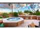Inviting hot tub with a full outdoor kitchen featuring stainless steel grill and covered patio for backyard entertaining at 17363 W Lisbon Ln, Surprise, AZ 85388
