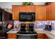 Well-equipped kitchen featuring granite countertops, wood cabinets, and stainless steel appliances at 17363 W Lisbon Ln, Surprise, AZ 85388