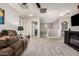 Open living room featuring plush carpeting, a ceiling fan, and fireplace at 17363 W Lisbon Ln, Surprise, AZ 85388