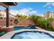 Beautiful swimming pool with waterfall feature and jacuzzi, surrounded by lush landscaping and desert plants at 17363 W Lisbon Ln, Surprise, AZ 85388