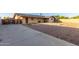 A gravel backyard featuring a covered patio and access to a gate and driveway at 1751 W Carol Ave, Mesa, AZ 85202