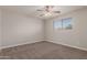 This carpeted bedroom offers a window for natural light and a ceiling fan at 1751 W Carol Ave, Mesa, AZ 85202