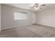 Bright bedroom with neutral carpeting, a ceiling fan, and a sunny window view at 1751 W Carol Ave, Mesa, AZ 85202