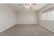 Spacious bedroom featuring neutral carpeting, a ceiling fan, and ample natural light at 1751 W Carol Ave, Mesa, AZ 85202
