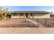 Charming single-story home with a neutral-toned exterior, gravel landscaping, and a fenced front yard at 1751 W Carol Ave, Mesa, AZ 85202