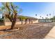 Quaint single-story home featuring low-maintenance rock landscaping and mature desert trees at 1751 W Carol Ave, Mesa, AZ 85202