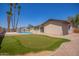 Backyard featuring an in-ground pool, artificial turf, desert landscaping, and palm trees at 18402 N 17Th Ave, Phoenix, AZ 85023