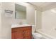 Bathroom featuring a wood vanity with a white countertop, a mirror and a shower and tub at 18402 N 17Th Ave, Phoenix, AZ 85023