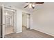 Cozy bedroom featuring a ceiling fan, carpeted floor, and a mirrored closet with a view to a hall at 18402 N 17Th Ave, Phoenix, AZ 85023