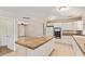 Bright kitchen features white cabinetry, tile countertops, and a center island with bar seating at 18402 N 17Th Ave, Phoenix, AZ 85023