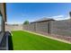 Fenced backyard with well-maintained artificial grass and a patio view at 18808 W Solano Dr, Litchfield Park, AZ 85340
