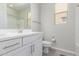 Bright bathroom with a single vanity, toilet, shower with bathtub and window at 18808 W Solano Dr, Litchfield Park, AZ 85340