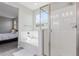 Bright bathroom showcasing a tub and glass shower with views into the bedroom at 18808 W Solano Dr, Litchfield Park, AZ 85340
