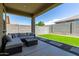 A covered patio has an outdoor seating area with views of the green backyard at 18808 W Solano Dr, Litchfield Park, AZ 85340