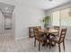 Cozy dining area featuring a round wooden table with four chairs and view of backyard through bright window at 18808 W Solano Dr, Litchfield Park, AZ 85340