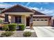 Charming single-story home with a two-car garage, stone accents, and well-maintained landscaping in front at 18808 W Solano Dr, Litchfield Park, AZ 85340
